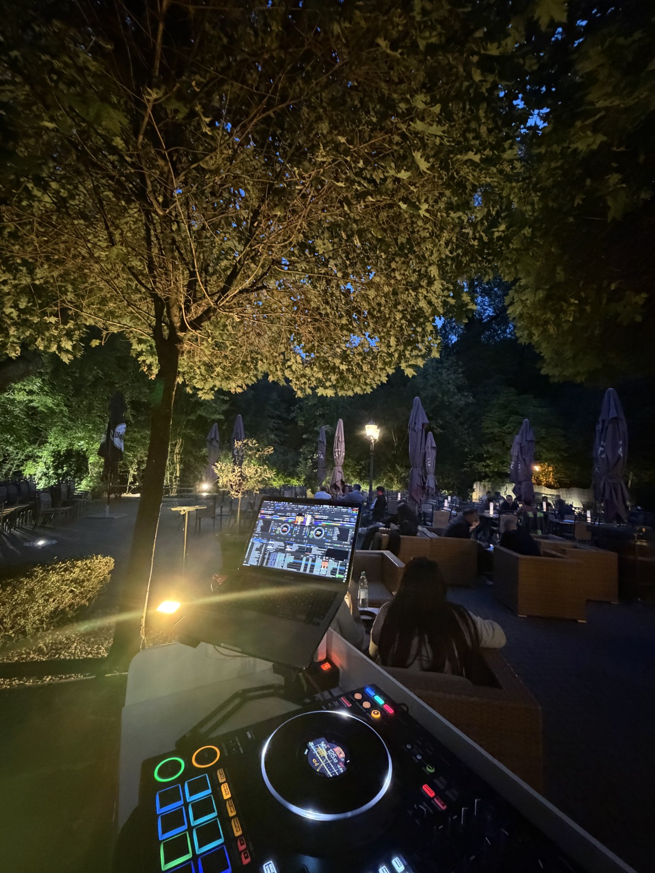 DJ-Pult und beleuchtete Bäume beim Feierabend am See